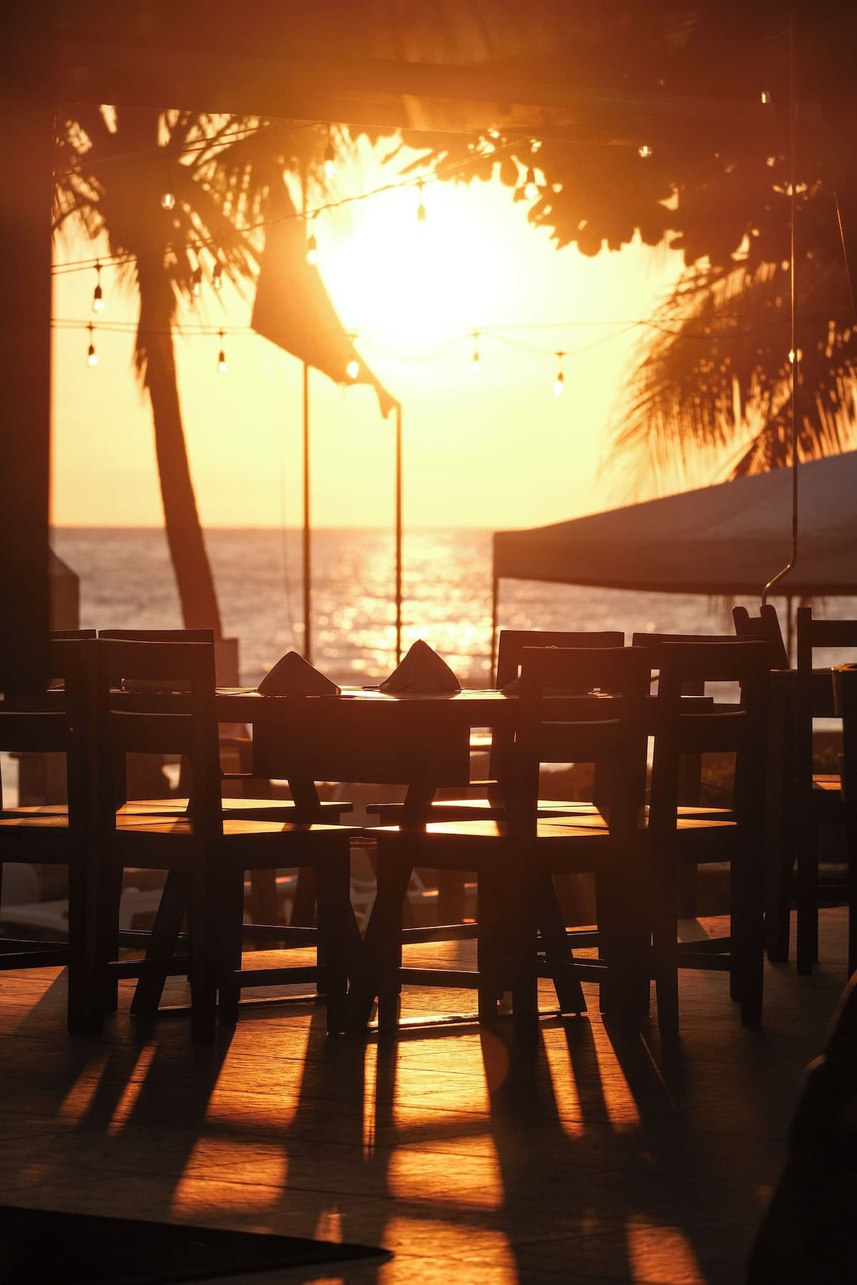 Sunset beachfront dining with string lights at Terraza del Pacífico